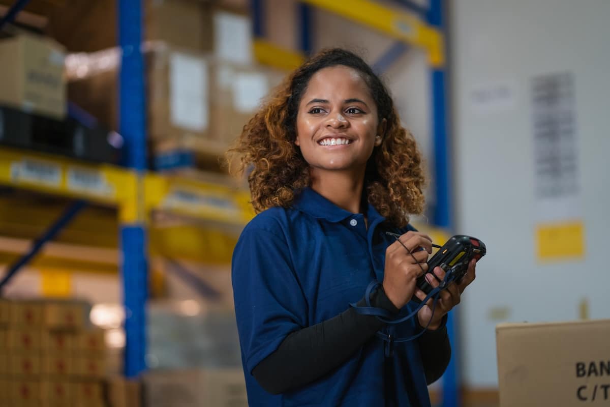 Warehouse worker in a manufacturing setting reviewing information in her workspace